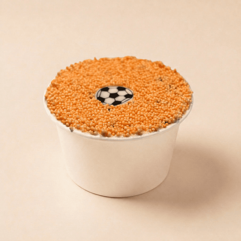 WK Special dotcake met witte roomkaas frosting, volledig afgewerkt met oranje spikkels en een voetbaldecoratie in het midden.